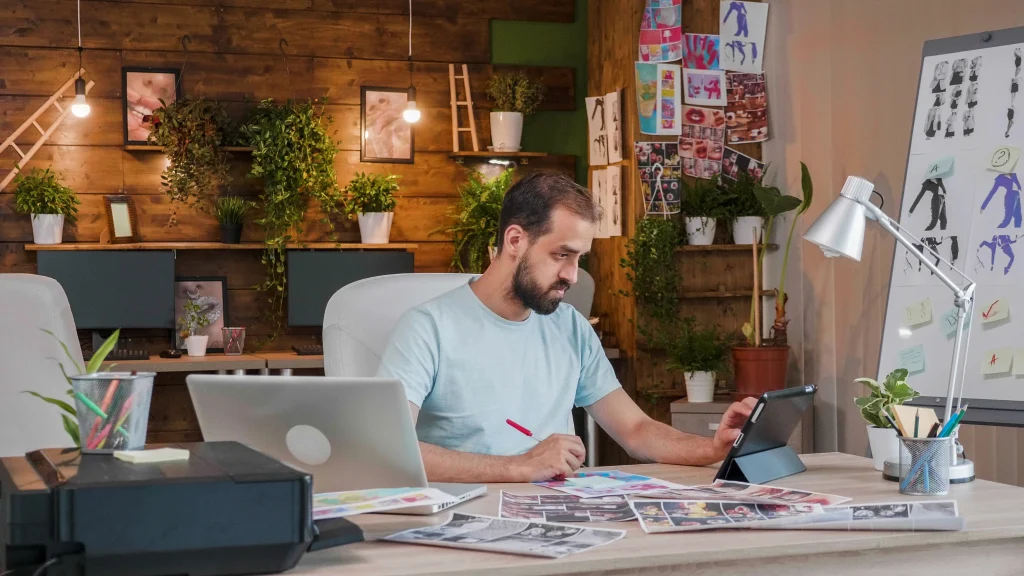 A male developer working on a digital tablet, focusing on custom website design for businesses to improve user experience.