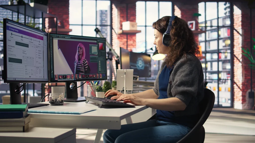 Professional editor performing animation video editing by AI on a dual-monitor workstation.