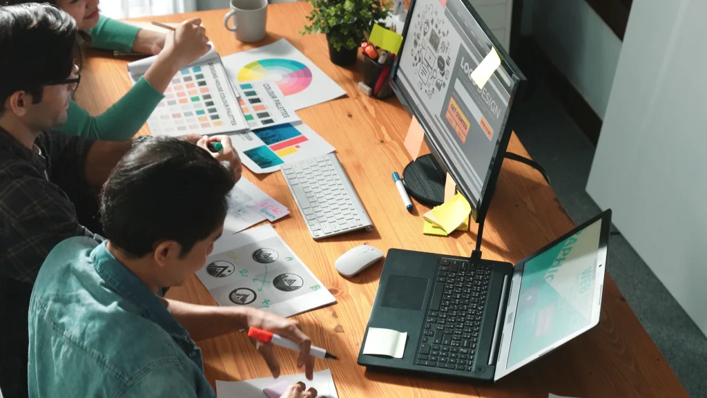 Design team collaborating on a professional monogram logo design for branding.