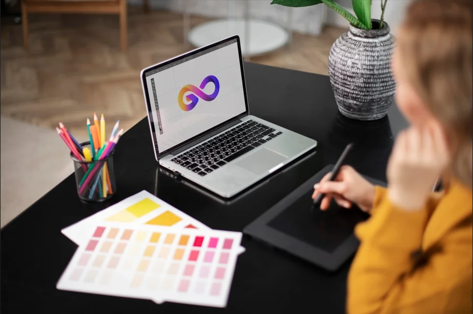 Graphic designer creating a modern infinity logo design trend 2026 on laptop