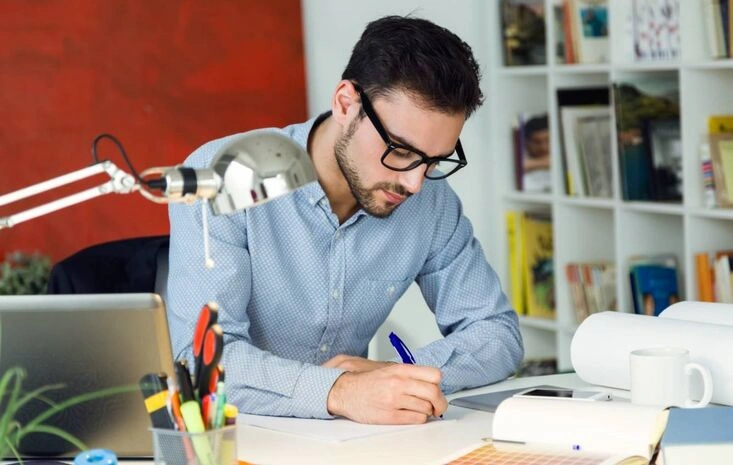 Creative designer sketching project ideas at workspace