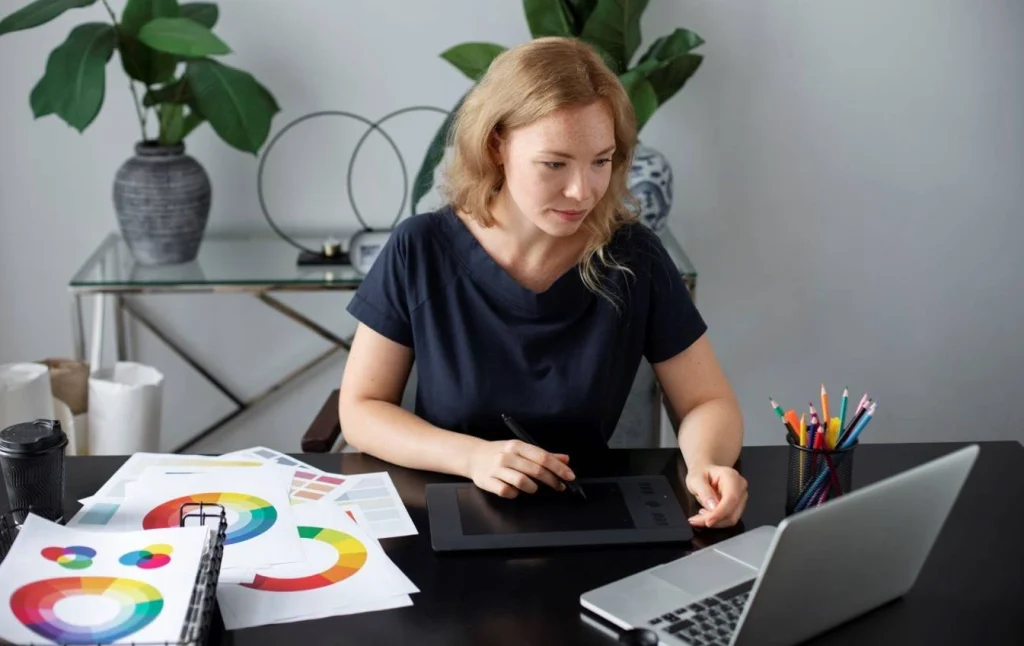 Female graphic designer working on digital tablet at office