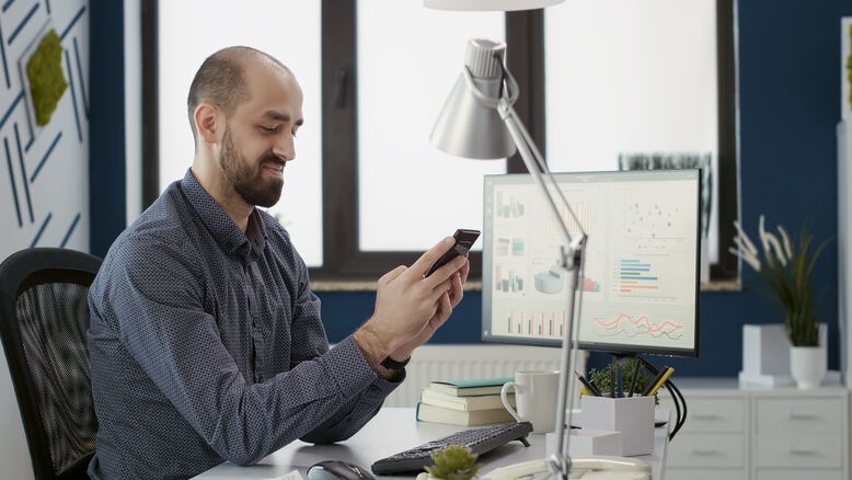 Business professional analyzing app development budget and project performance on a smartphone