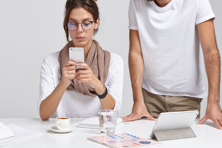 Business professionals reviewing a mobile app development project on smartphones and tablets